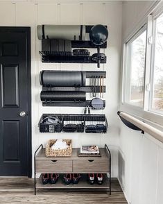 a black door and some shelves in a room with shoes on the floor next to it