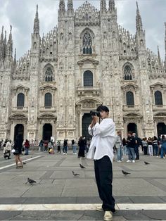 a man standing in front of a large cathedral