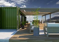 an outdoor living area with couches, table and potted plant on the deck