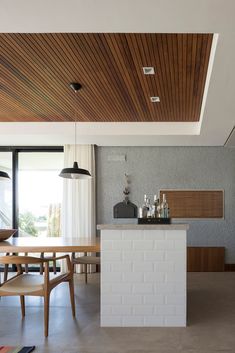 an open kitchen and dining room with wooden ceiling