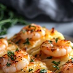 some shrimp and pasta on a plate with parsley sprinkled around it's edges