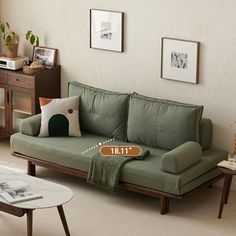 a living room filled with furniture and pictures on the wall next to a coffee table