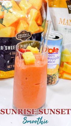 a smoothie in a glass next to some pineapples and other fruit on the table