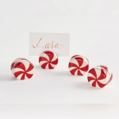 three red and white candy canes sitting next to a card