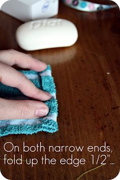 a person wiping up the edge of a cloth on a table with a toothbrush