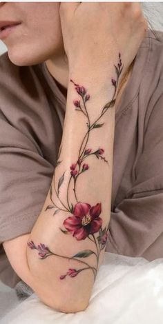 a woman's arm with flowers on it and the words fleur noire tattoo grand