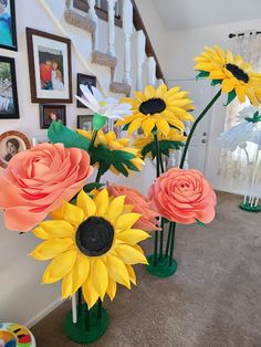 three vases filled with fake sunflowers and roses