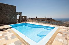 an empty swimming pool on the roof of a building with stone walls and flooring