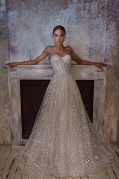 a woman standing in front of a fire place wearing a dress with sequins