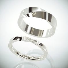 two silver rings with diamonds on them sitting next to each other in front of a white background