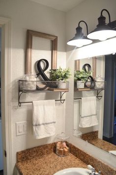 a bathroom sink with two towels hanging on the wall and some plants in baskets above it