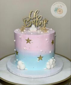 a pink, blue and gold cake with stars on top that says'oh sweet '