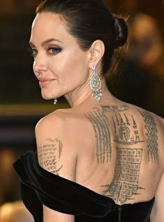 the back of a woman's neck with tattoos on her chest and shoulder,