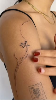 a woman's arm with tattoos on it and a small bird flying over her shoulder