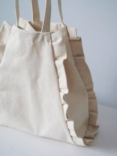 a white bag with ruffles on it sitting on a table