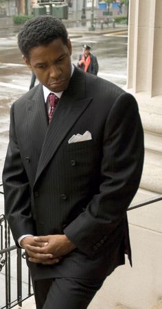 a man in a suit and tie is standing outside