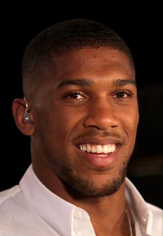 a close up of a person wearing a white shirt and silver earring on his left ear