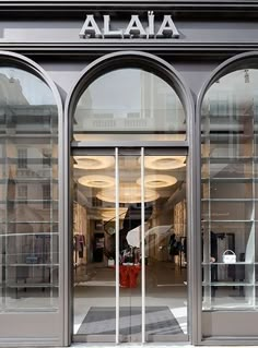 the front entrance to a store with arched glass doors