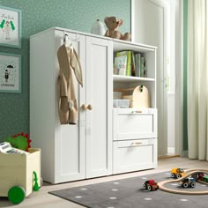 a child's bedroom with green walls and toys on the floor, including a toy car