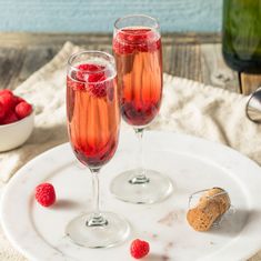 two glasses of raspberry champagne on a white plate