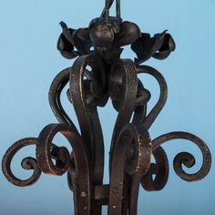 an ornate wrought iron candle holder against a blue background