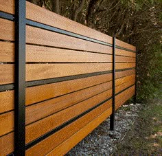 a wooden fence in front of some trees