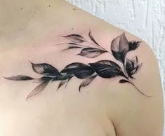 a woman's shoulder with black leaves on the top and bottom half - sleeve