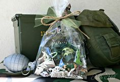 an assortment of items is sitting on a table next to a green bag and backpack