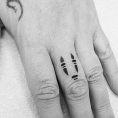 two fingers with black ink on them and one has an arrow tattoo on the middle finger