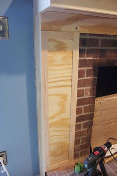 a brick fireplace being built in the corner of a room