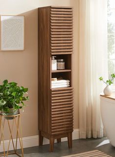 a bathroom with a wooden cabinet next to a potted plant