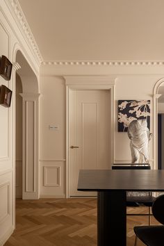 an elegant dining room with white walls and wood flooring