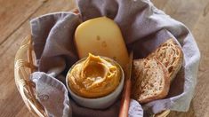 a basket filled with bread and butter on top of a wooden table