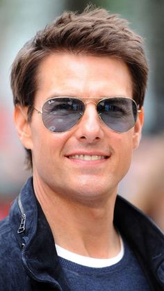 the man is wearing sunglasses and smiling at the camera