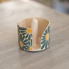 a ceramic flower design ring sitting on top of a table