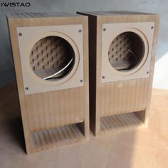 two wooden speakers sitting side by side on a table