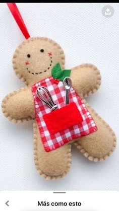 an ornament made to look like a teddy bear with scissors in its pocket