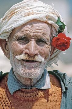 an old man with a rose in his hair