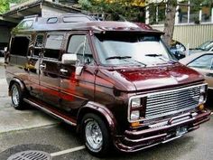 a maroon van is parked in a parking lot