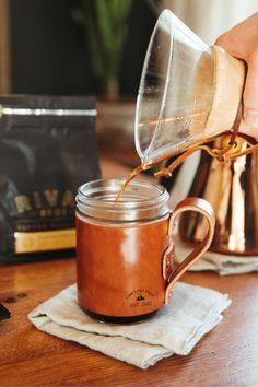 a person pours coffee into a mason jar