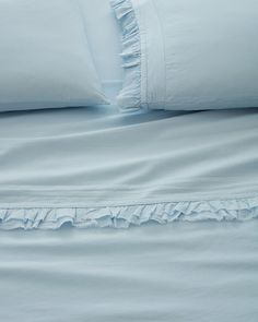 an unmade bed with white sheets and blue comforter on it's side