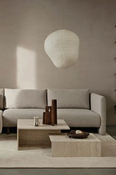 a living room filled with furniture and a white lamp hanging over the top of it