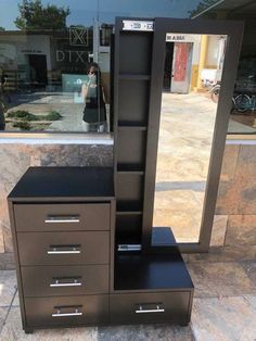 a black dresser and mirror in front of a store