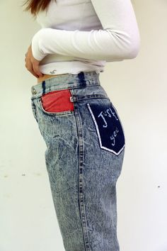 "Vintage acid wash jeans a lot of love left in these jeans, high waist tapered legs, pockets in colors - red blue, and yellow, embroidered back pocket (looks like hand embroidered by the previous owner ) the belt loops were removed -Looks appropriate with the overall look of the jeans, zipper Ankle, brand TOPPER - vintage Israeli brand. aside from minor signs of wear, good vintage condition, clean ready to wear. *Model is 5'7\" and a size small for reference** Approximate size: S -  Please refer Red Wide-leg Denim Jeans, Red Relaxed Fit Denim Jeans, Red Denim Jeans With Relaxed Fit, Red Denim Bottoms With Five Pockets, High Rise Red Denim Pants, High Waist Red Denim Jeans, Red Retro Denim Bottoms, 90s Inspired Medium Wash Cotton Jeans, Retro High Waist Red Jeans