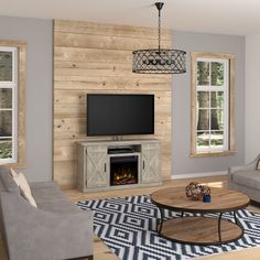 a living room with gray couches and a tv on a stand in front of a fireplace