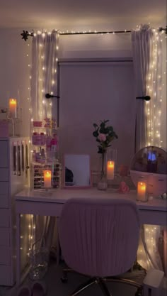 a white desk topped with a laptop computer next to a window covered in fairy lights