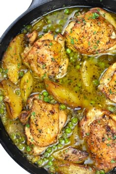 chicken with peas and potatoes in a skillet on a white table top, ready to be eaten