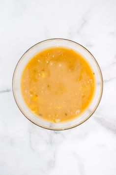 a bowl filled with yellow liquid on top of a white counter