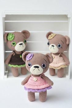 three crocheted teddy bears dressed in dresses