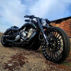 a black motorcycle parked on top of a dirt field